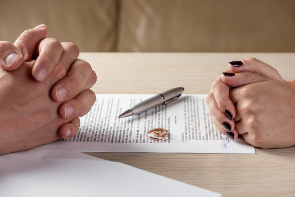 Wife and husband signing divorce documents or premarital agreement