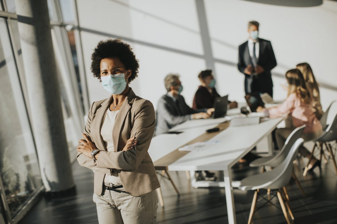 Woman with Mask Standing in Conference Room