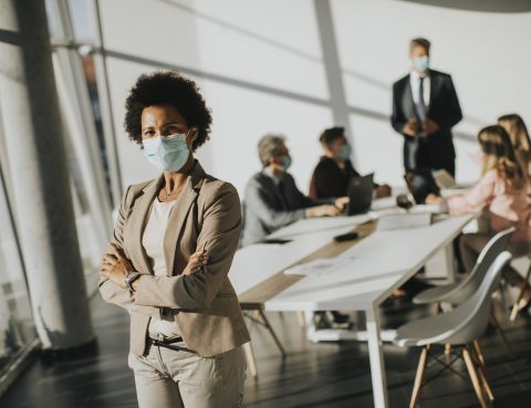 Woman with Mask Standing in Conference Room
